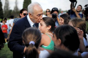 L'ex presidente israeliano Shimon Peres bacia una ragazza durante l'evento di apertura dell'anno formativo di un programma di calcio israelo-palestinese lanciato dal Centro Peres per la Pace, in Kibbutz Dorot.